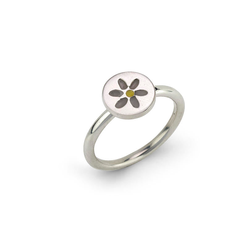 Silver ring with a round, white setting featuring a stylized grey and yellow daisy.