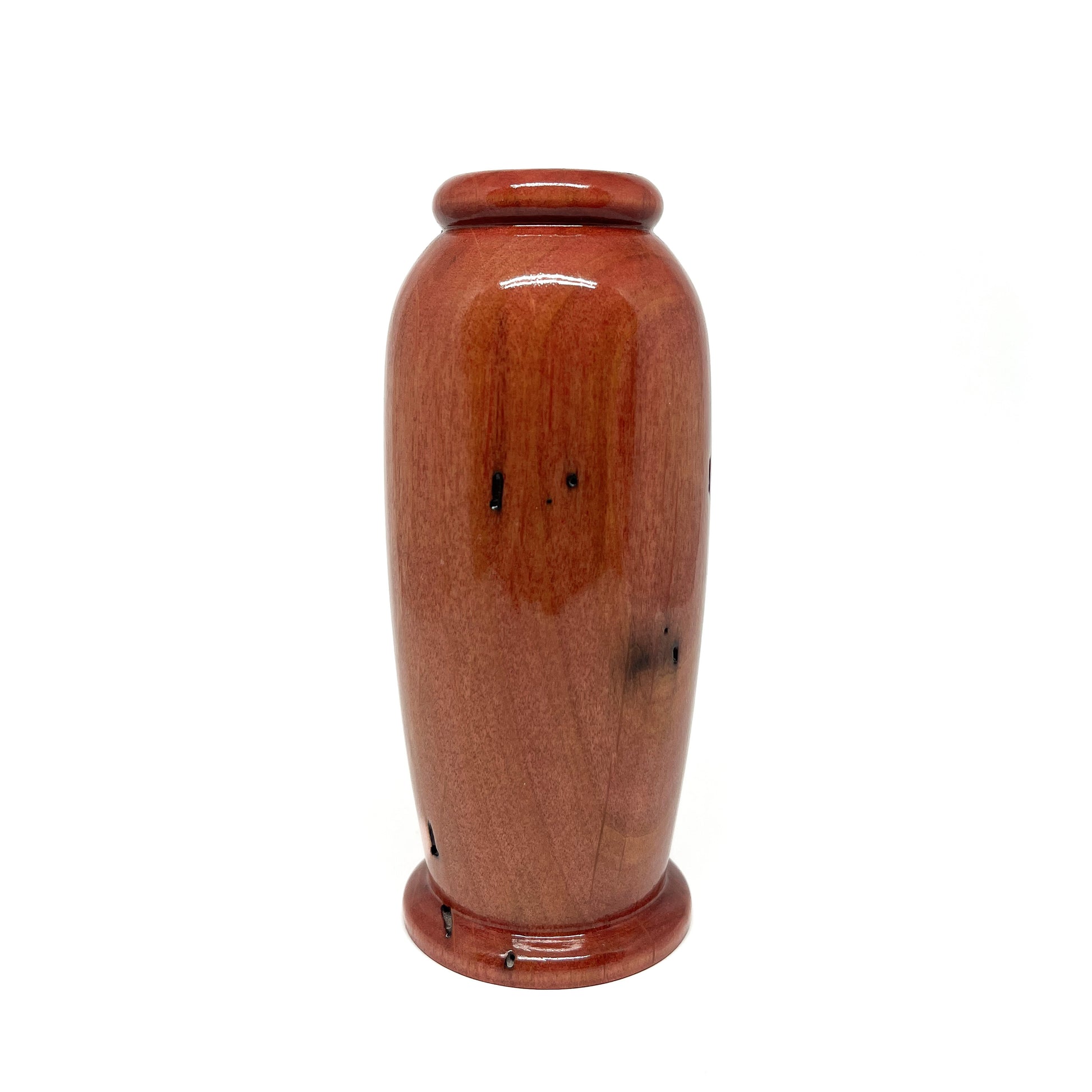 Small, polished wooden urn with a warm, reddish-brown tone and subtle natural wood markings.