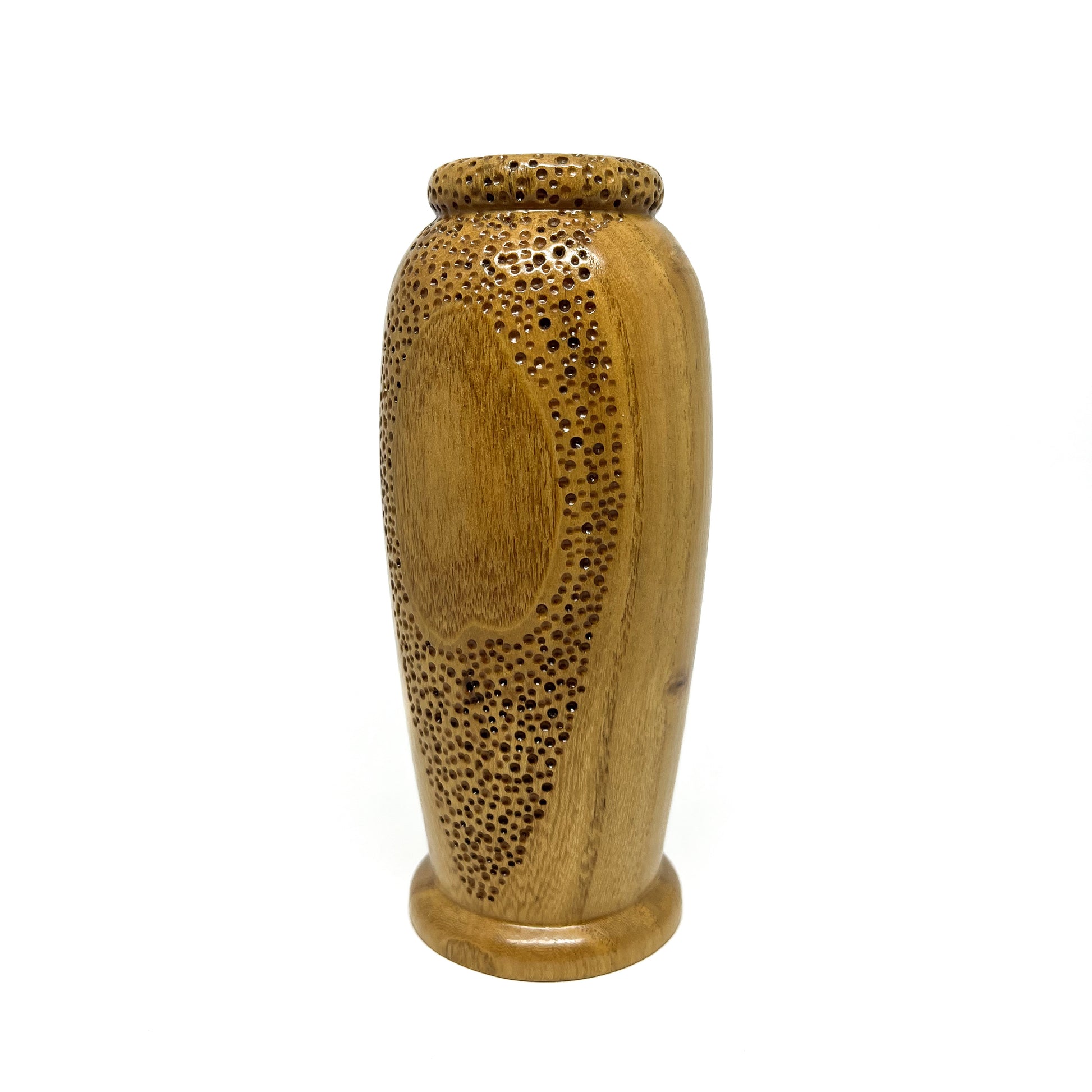 Small wooden vase with a textured surface featuring carved circular patterns and small perforations.