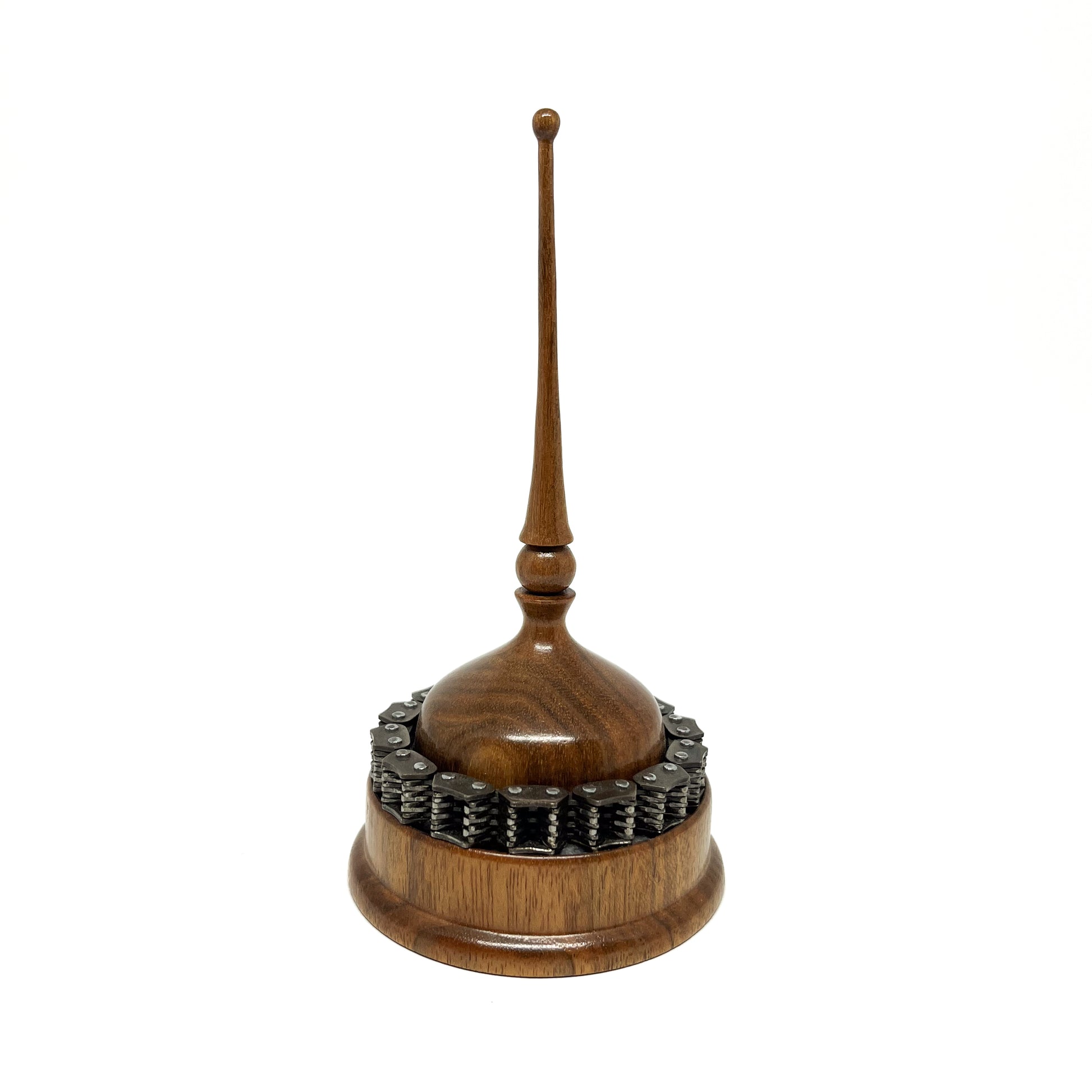 Wooden mixed media spire sculpture with a chain detail around the base and a slender, topped spire.