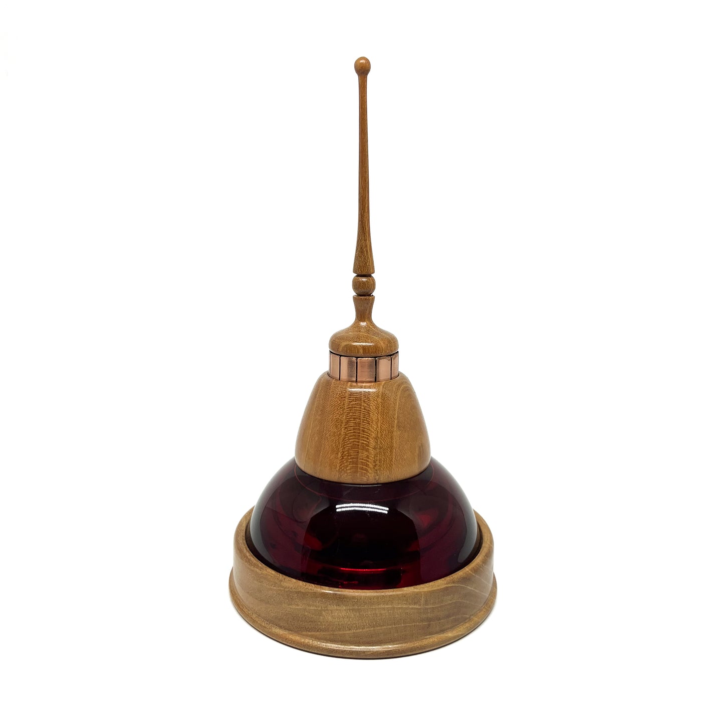 Mixed media sculpture with a dark red glass dome, wooden base and top, copper accents, and a slender wooden spire.