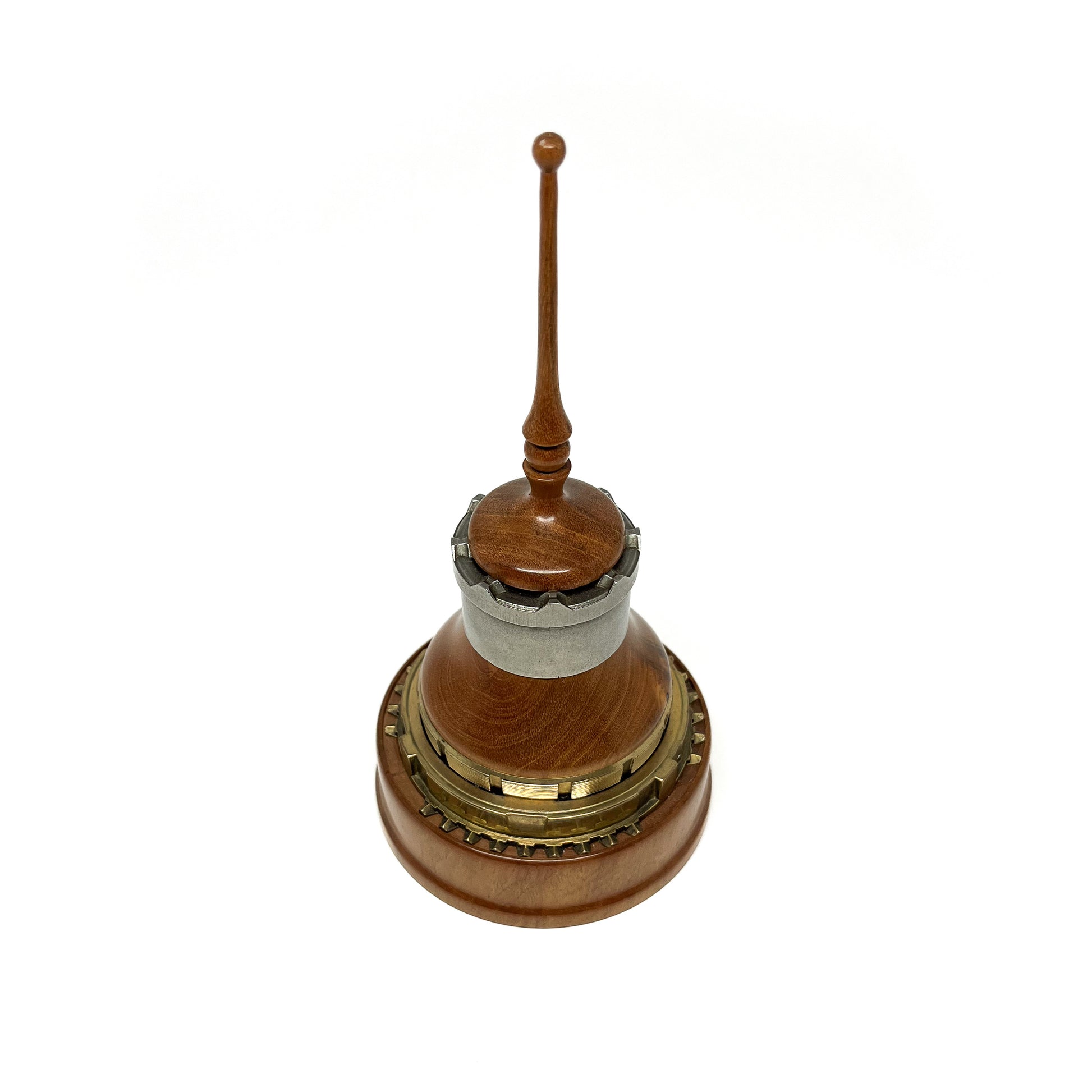 Wooden mixed media spire sculpture with metal rings and a slender, topped spire.