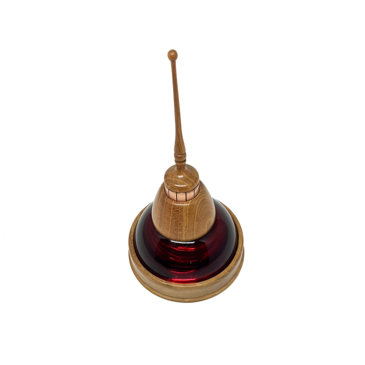 Overhead view of a mixed media sculpture with a dark red glass dome, wooden elements, copper details, and a thin spire.