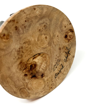 Close-up of the textured wooden base of a sculpture with a handwritten signature "David Adolph 2022".