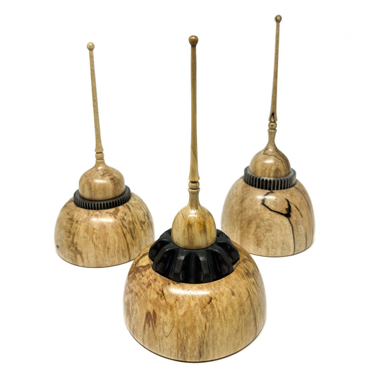 Three small wood spire sculptures by David Adolph, each with unique wood grain and textured elements.