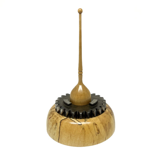 Small wood spire sculpture by David Adolph with a cog-like dark ring and a slender, topped spire.