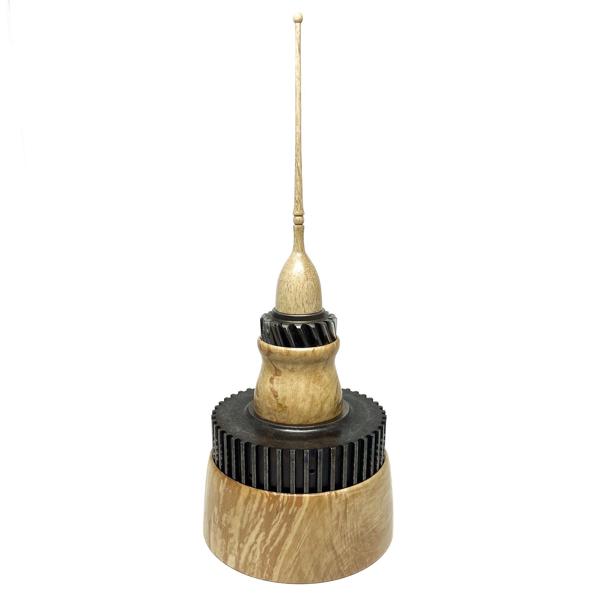 Stacked wood spire sculpture by David Adolph with two dark, cog-like rings and a tall, slender, topped spire.