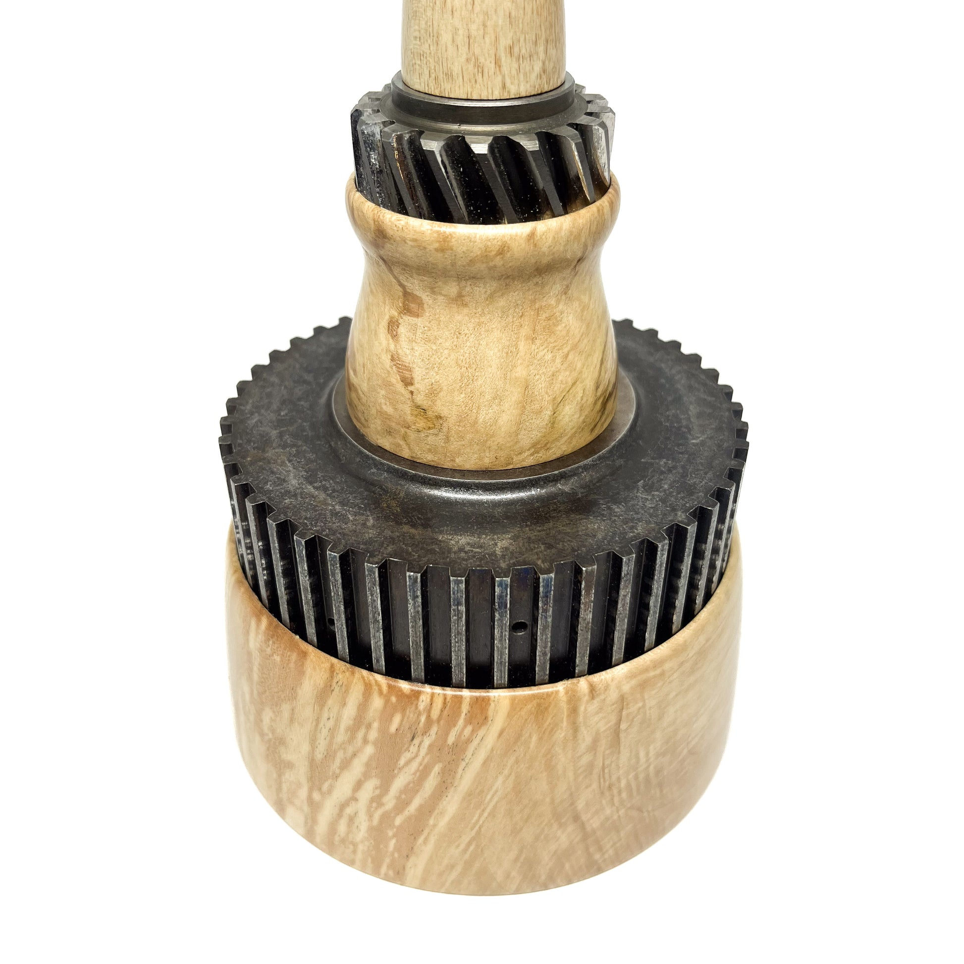 Close-up of a stacked wood spire sculpture by David Adolph with two dark, cog-like rings.