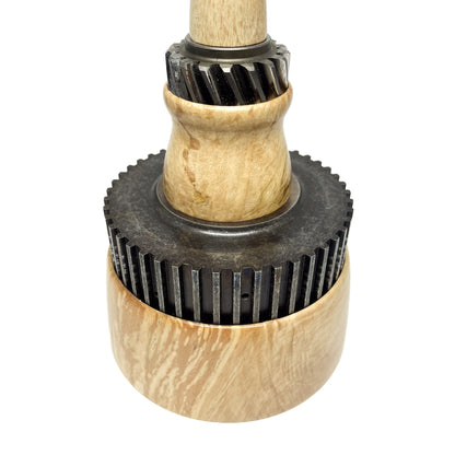 Close-up of a stacked wood spire sculpture by David Adolph with two dark, cog-like rings.