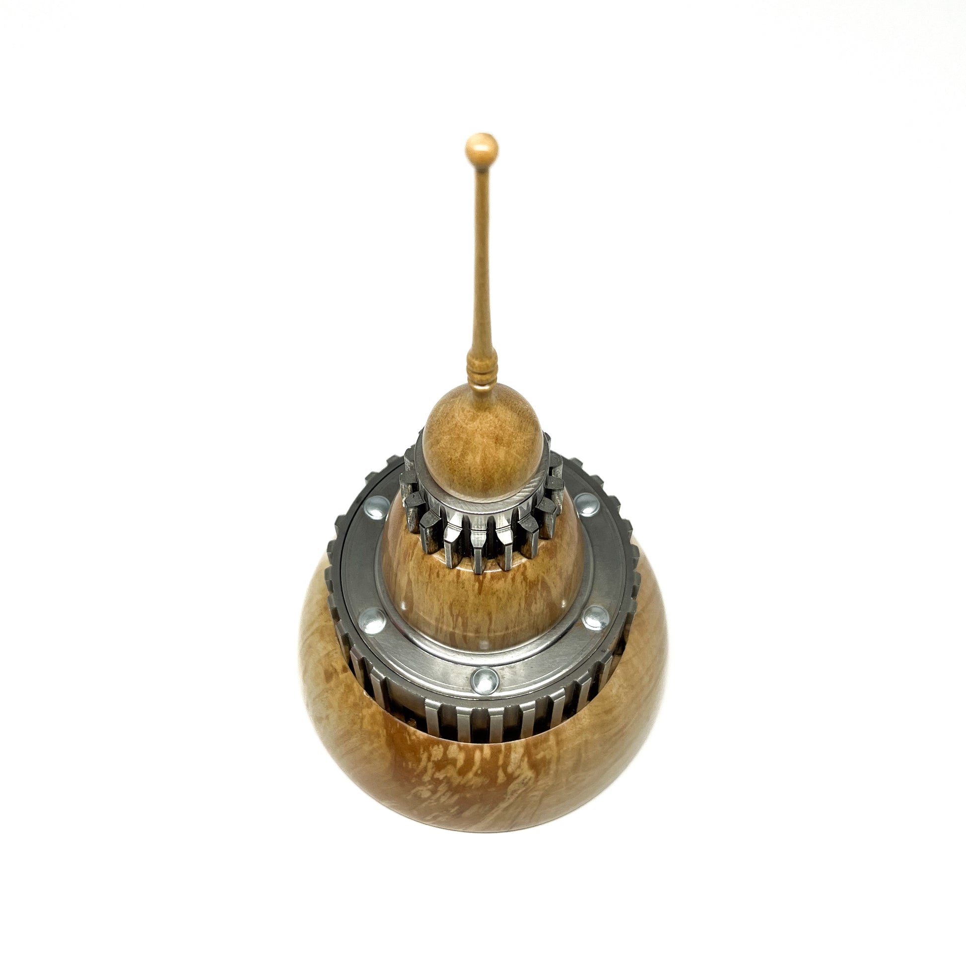 Overhead view of a stacked wood spire sculpture by David Adolph with multiple dark, cog-like rings and a slender top.
