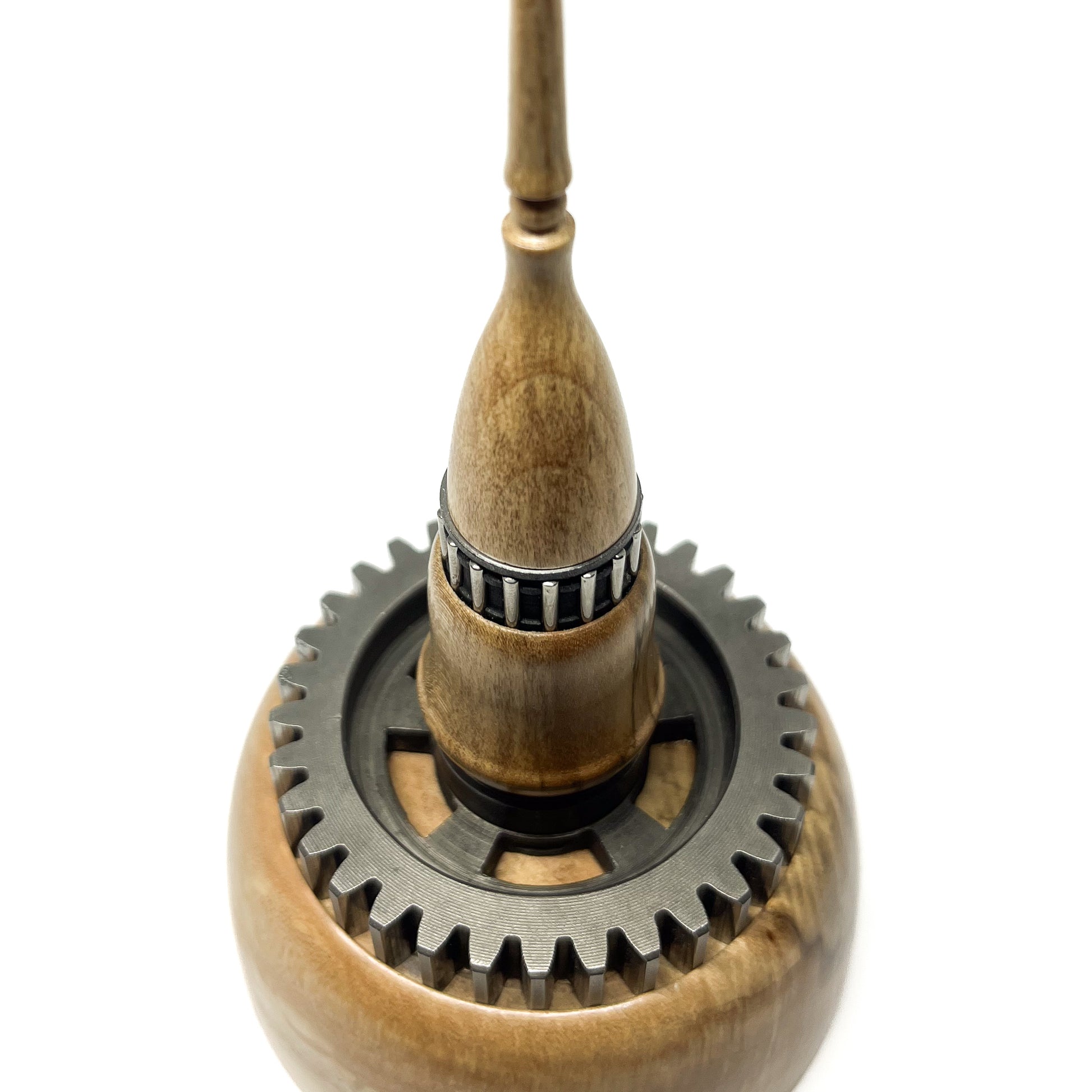 Close-up overhead view of a stacked wood spire sculpture by David Adolph with two dark, detailed rings and slender top.