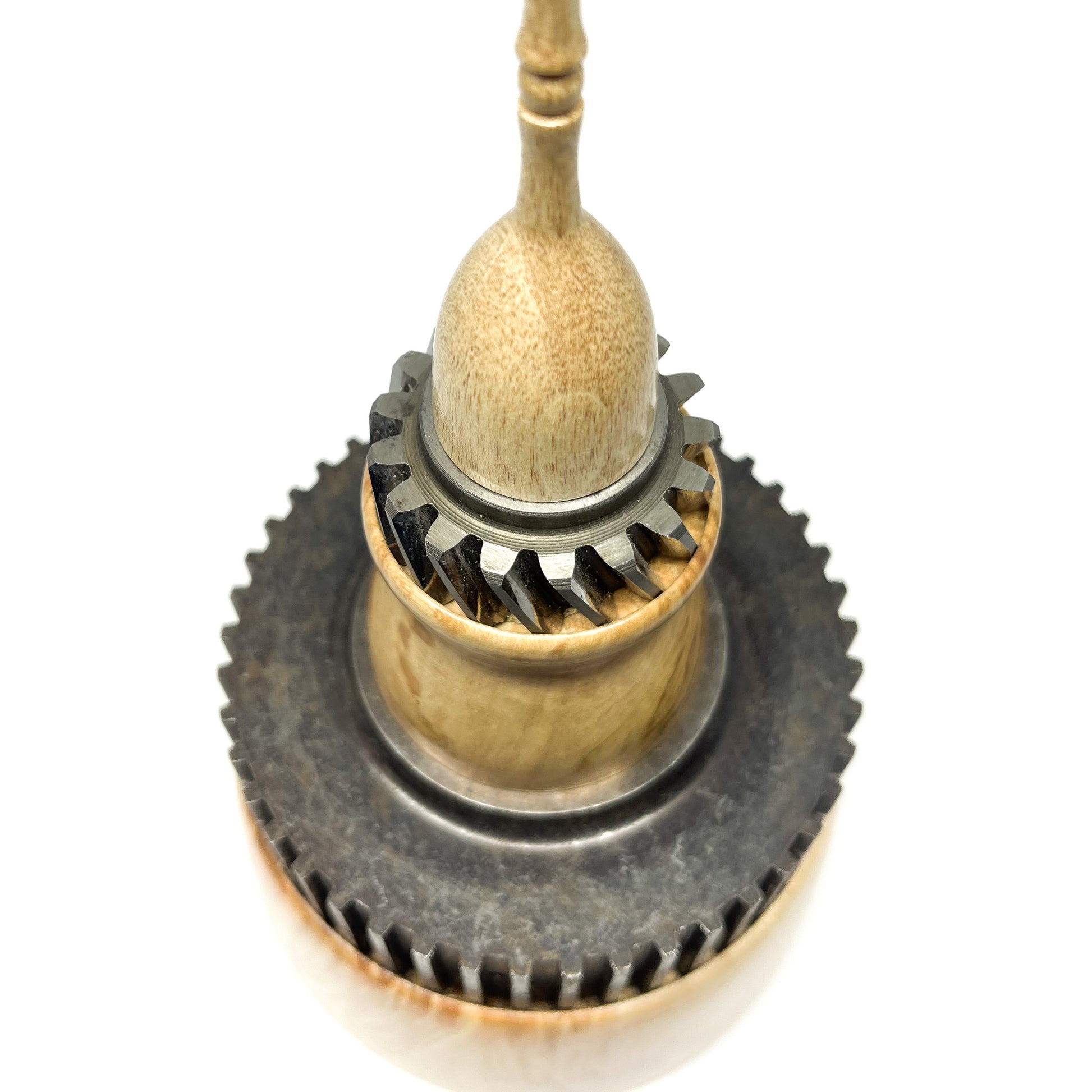 Close-up overhead view of a stacked wood spire sculpture by David Adolph with two dark cog-like rings and slender top.