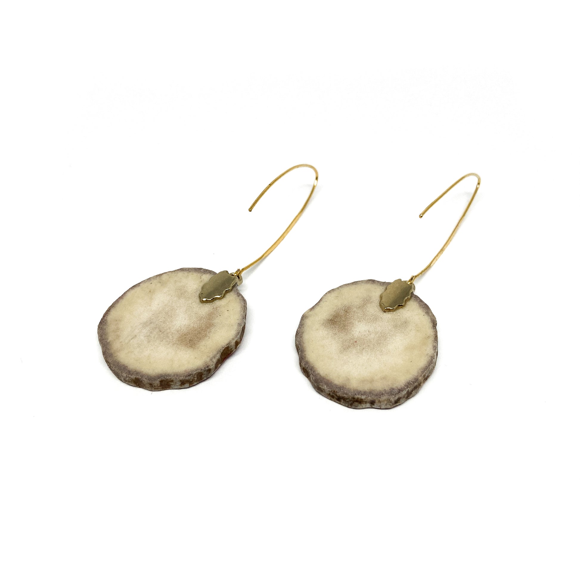 Two round earrings made from slices of antler, featuring gold caps and hooks.