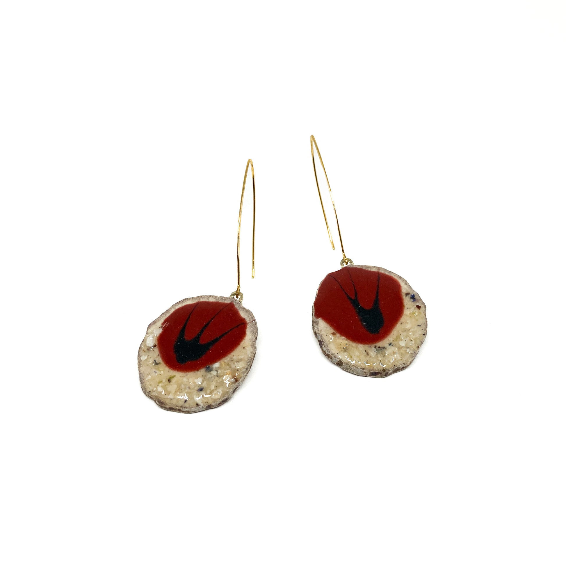 Two round earrings with red and black bird-shaped designs, featuring gold hooks.