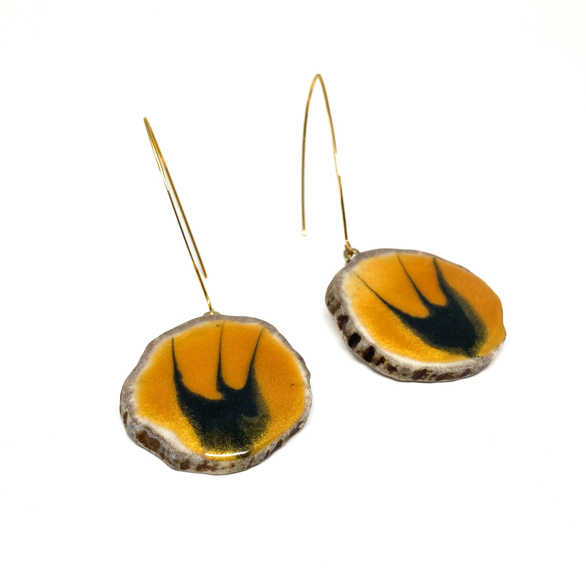 Two round earrings with yellow and black bird-shaped designs, featuring gold hooks.