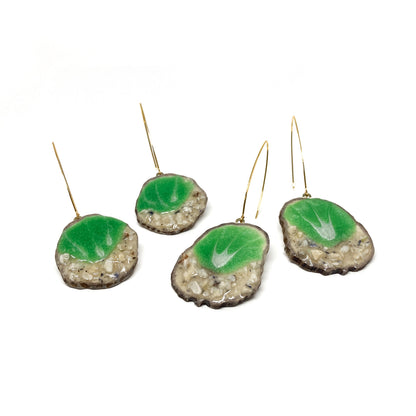 Four round earrings with green leaf-shaped designs, featuring gold hooks.