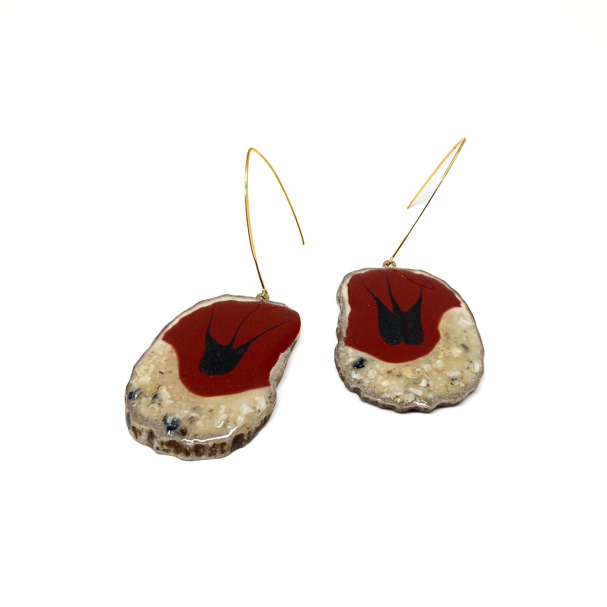 Two round earrings with red and black bird-shaped designs, featuring gold hooks.
