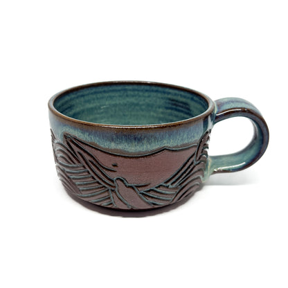 Ceramic mug with a raised whale tail design and a glossy, handcrafted finish around the exterior.