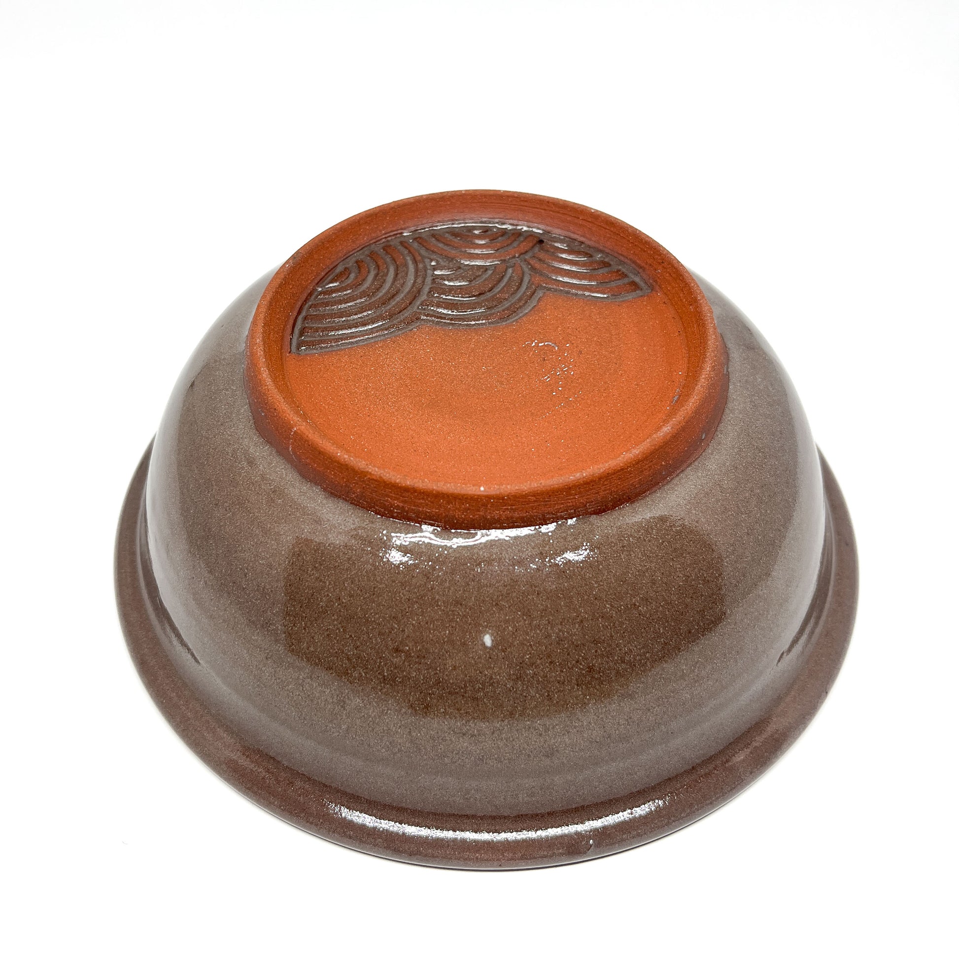 Bowl featuring a carved orca swimming across layered waves with a large sun or moon in the background.