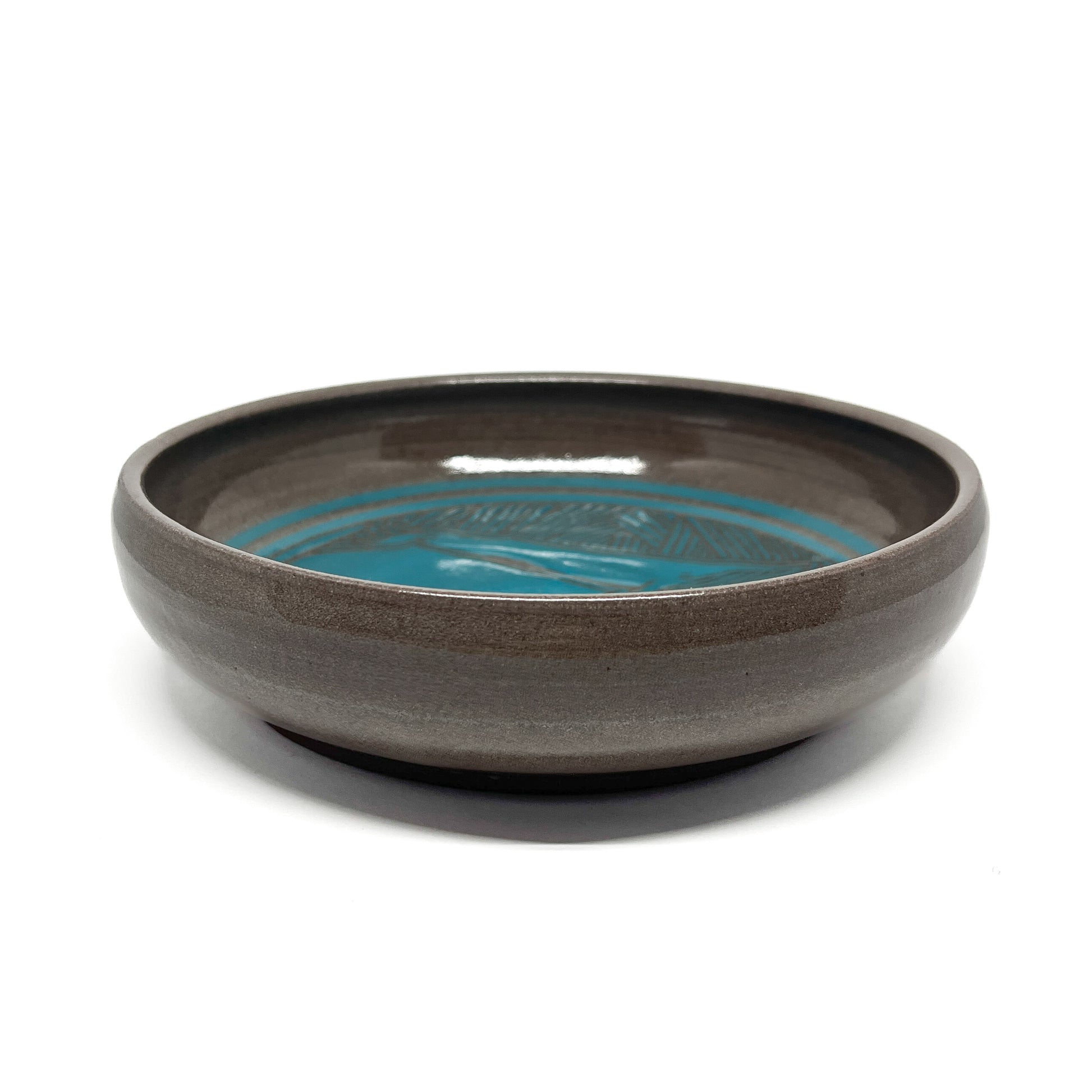 A blue ceramic bowl with a horizontal stripe design.