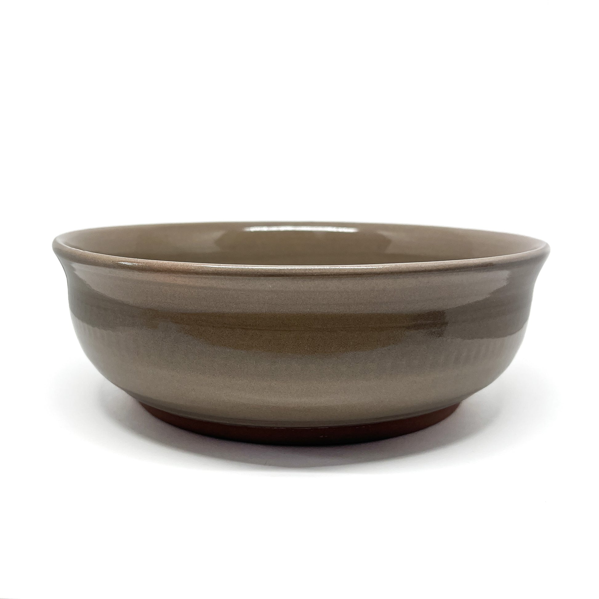 Underside of a bowl showing a carved whale in a circular medallion framed by stylized wave patterns.