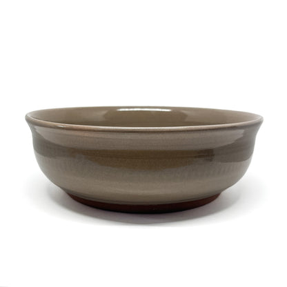 Underside of a bowl showing a carved whale in a circular medallion framed by stylized wave patterns.