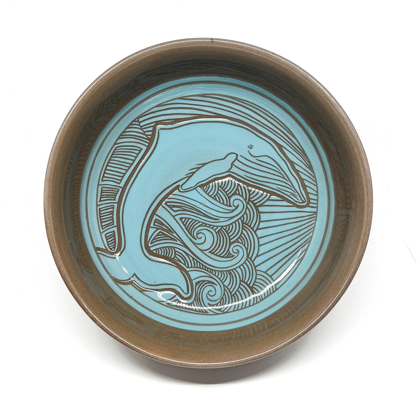 Top view of a bowl with a detailed octopus carving, framed by dynamic wave and sunburst lines.