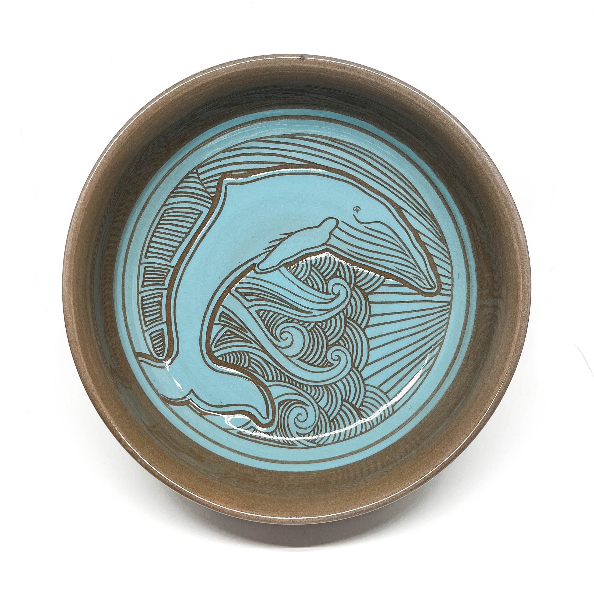 Top view of a bowl with a detailed octopus carving, framed by dynamic wave and sunburst lines.