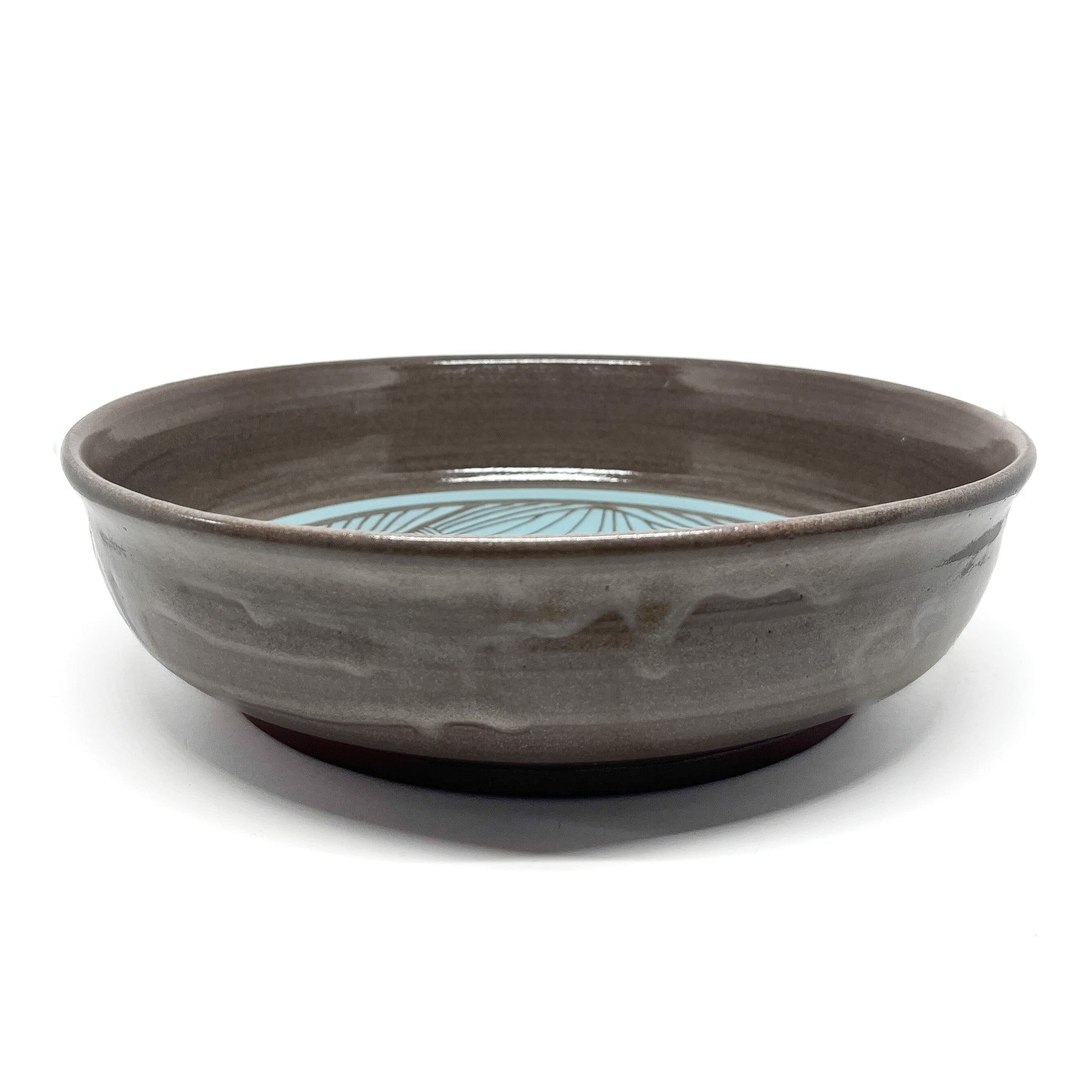 Ceramic bowl with a glazed finish and a decorative interior pattern featuring radial lines.