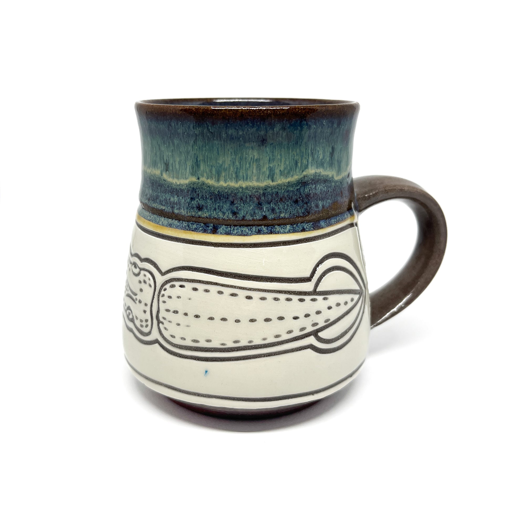 Ceramic mug with a carved squid illustration, featuring a glossy glazed rim and a side handle.