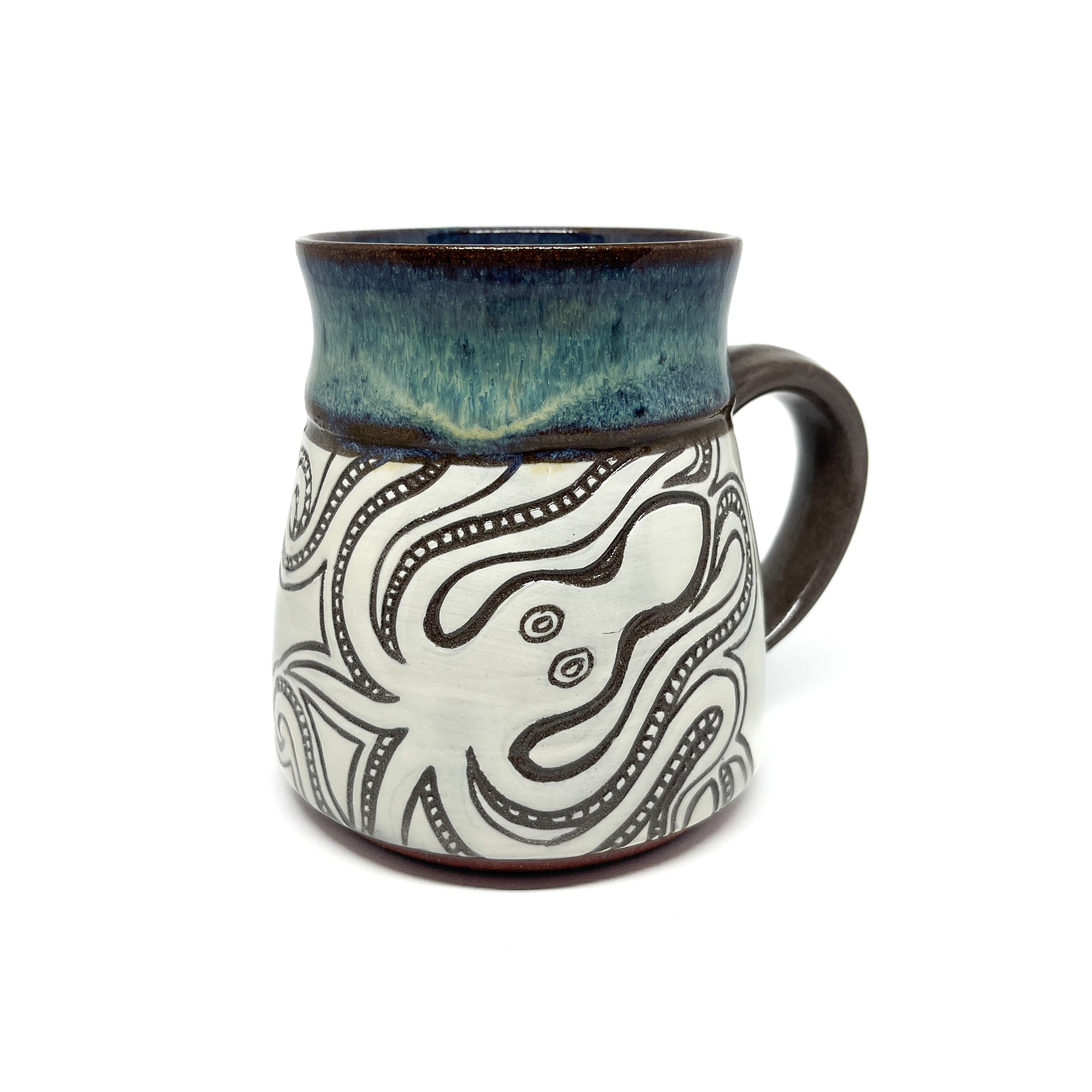 Mug with multiple carved squid designs swimming among stylized waves, handle visible.