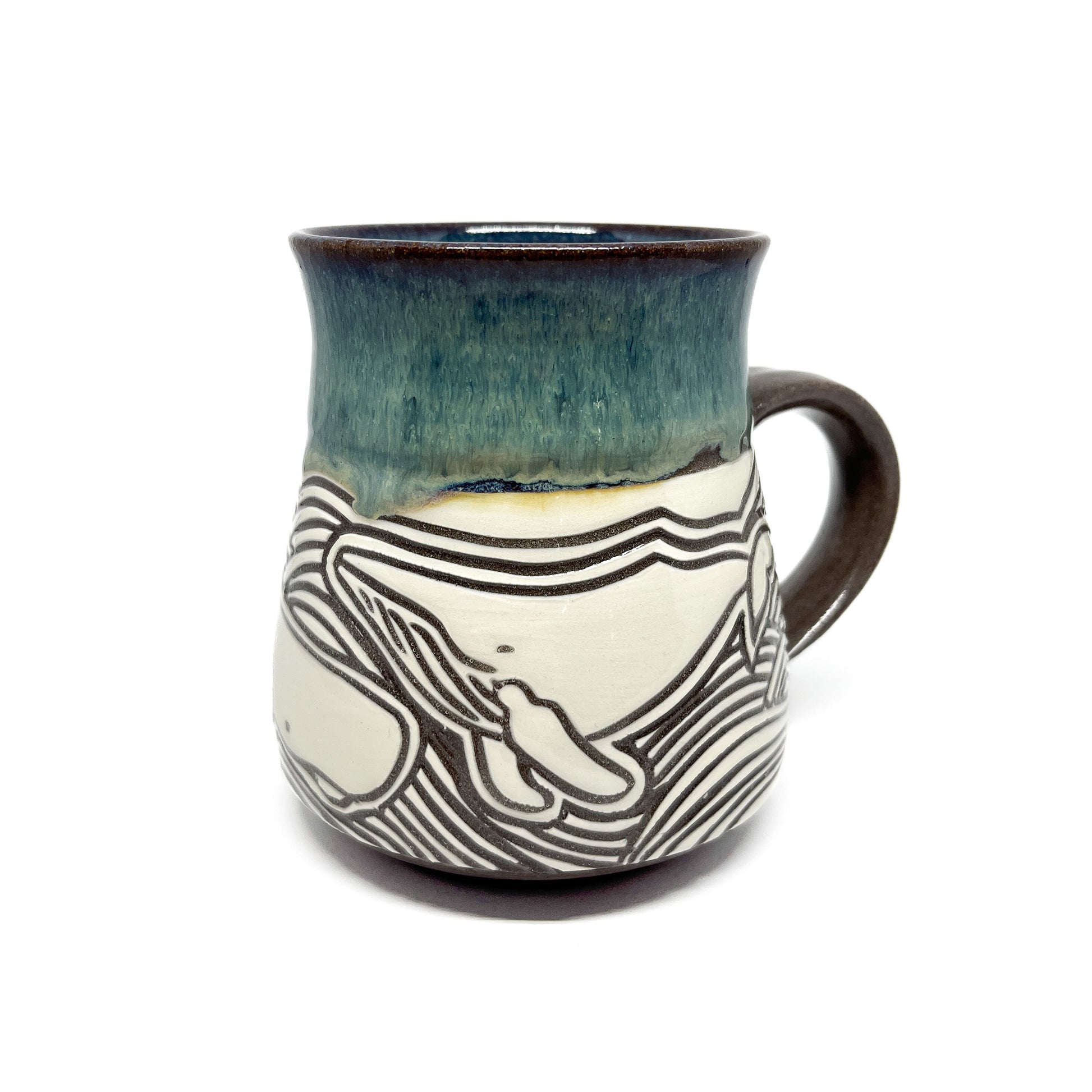 Ceramic mug showing a single whale surrounded by stylized ocean waves, with a glossy upper rim.