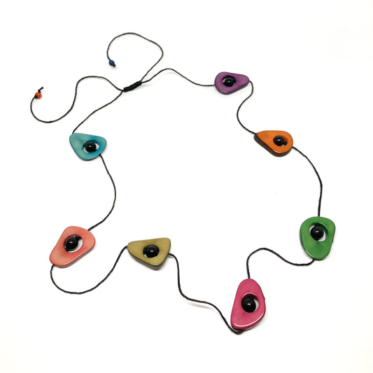 A necklace with colorful, irregularly shaped stones and black beads on a thin black cord, laid flat.