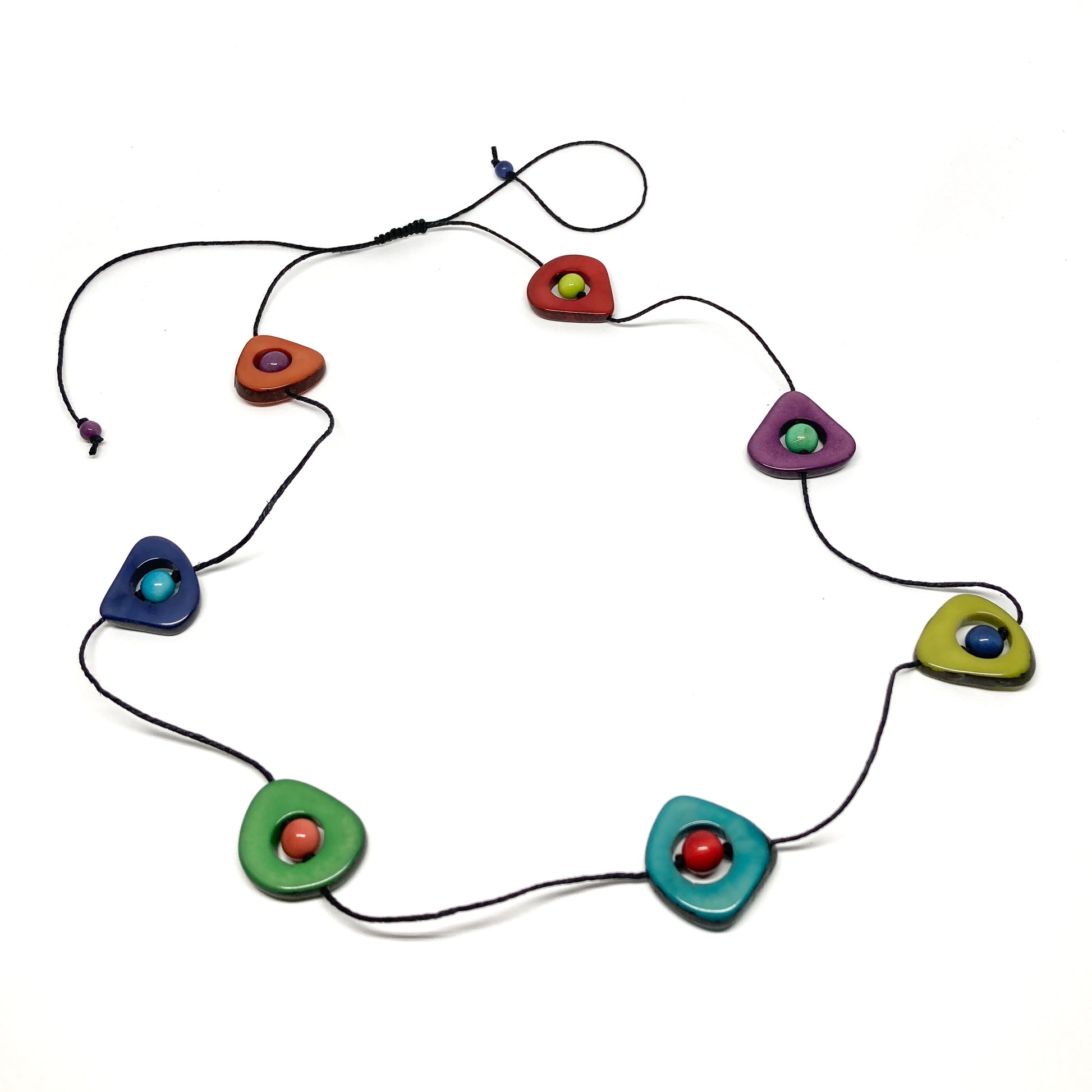 A necklace with colorful stones and black beads on a thin black cord, laid flat in a circular pattern.