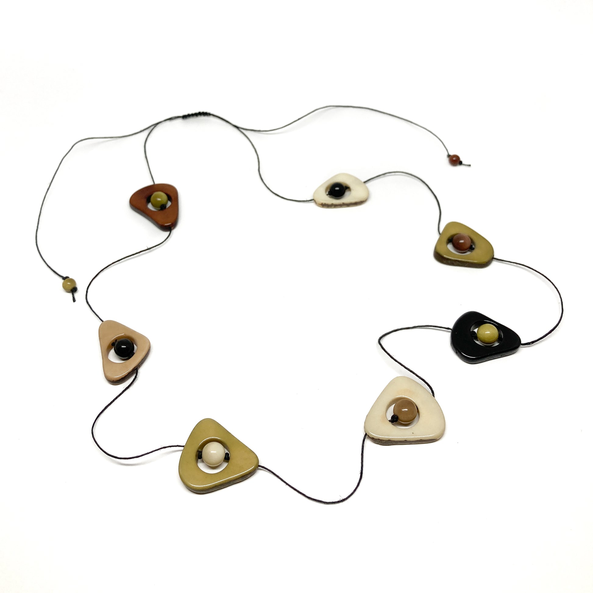 A necklace with earth-toned stones and black beads on a thin black cord, laid flat in a circular pattern.