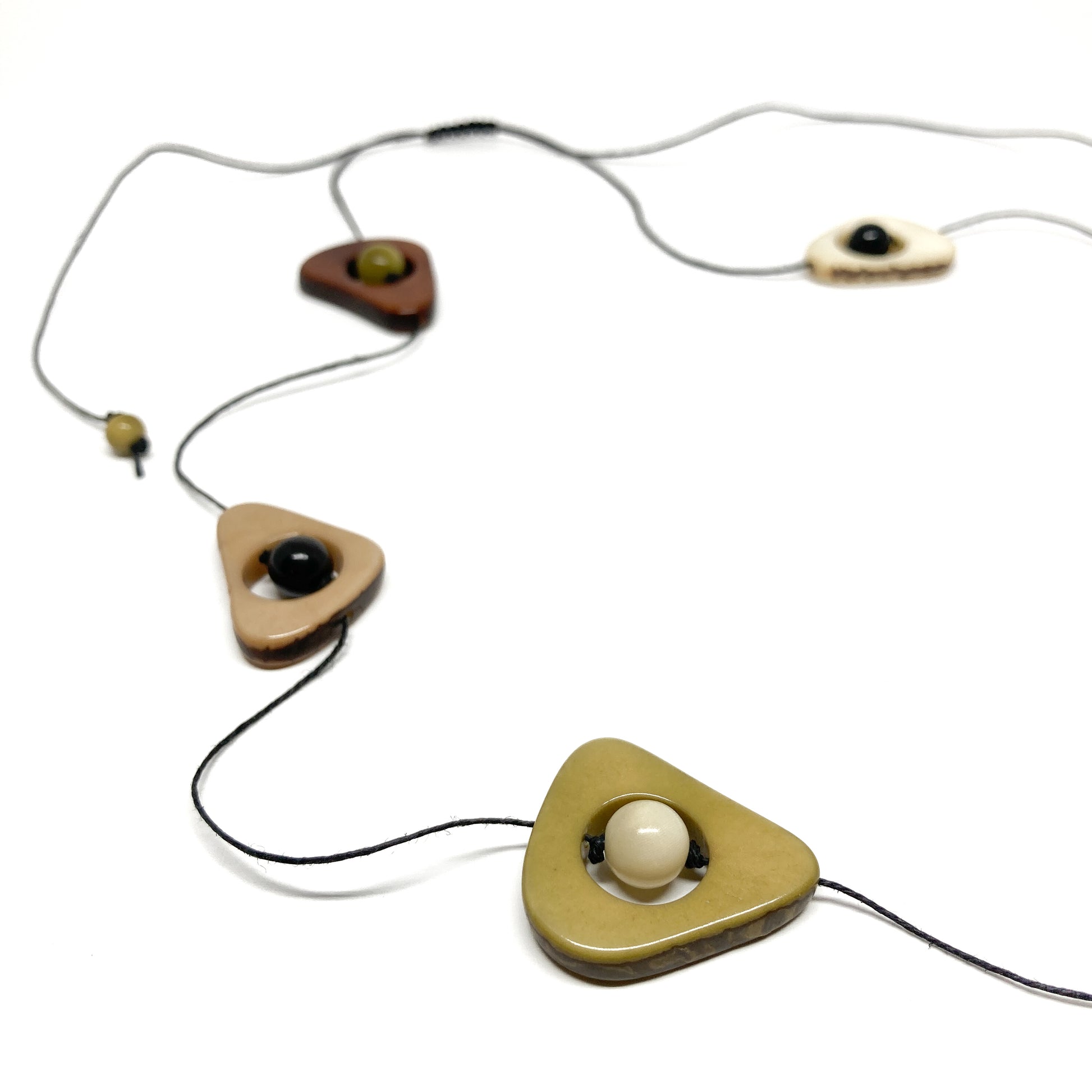 Necklace with triangle pendants, beads, and string on white background.