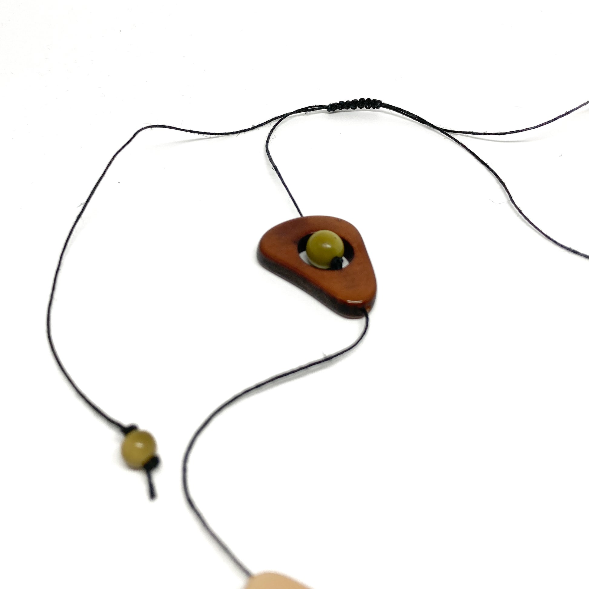 Necklace with a brown triangular pendant and a yellow bead.