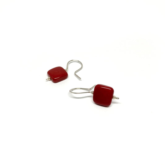 Two red square earrings with silver hooks.