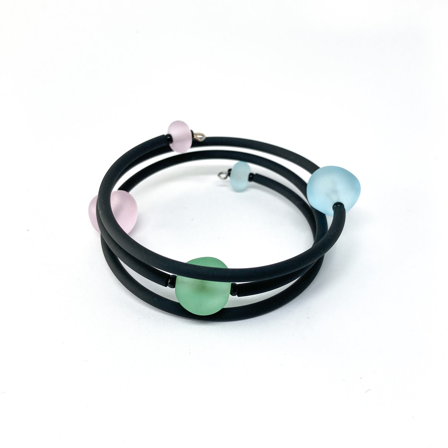 Black rubber bracelet with pink, light blue, and green beads.