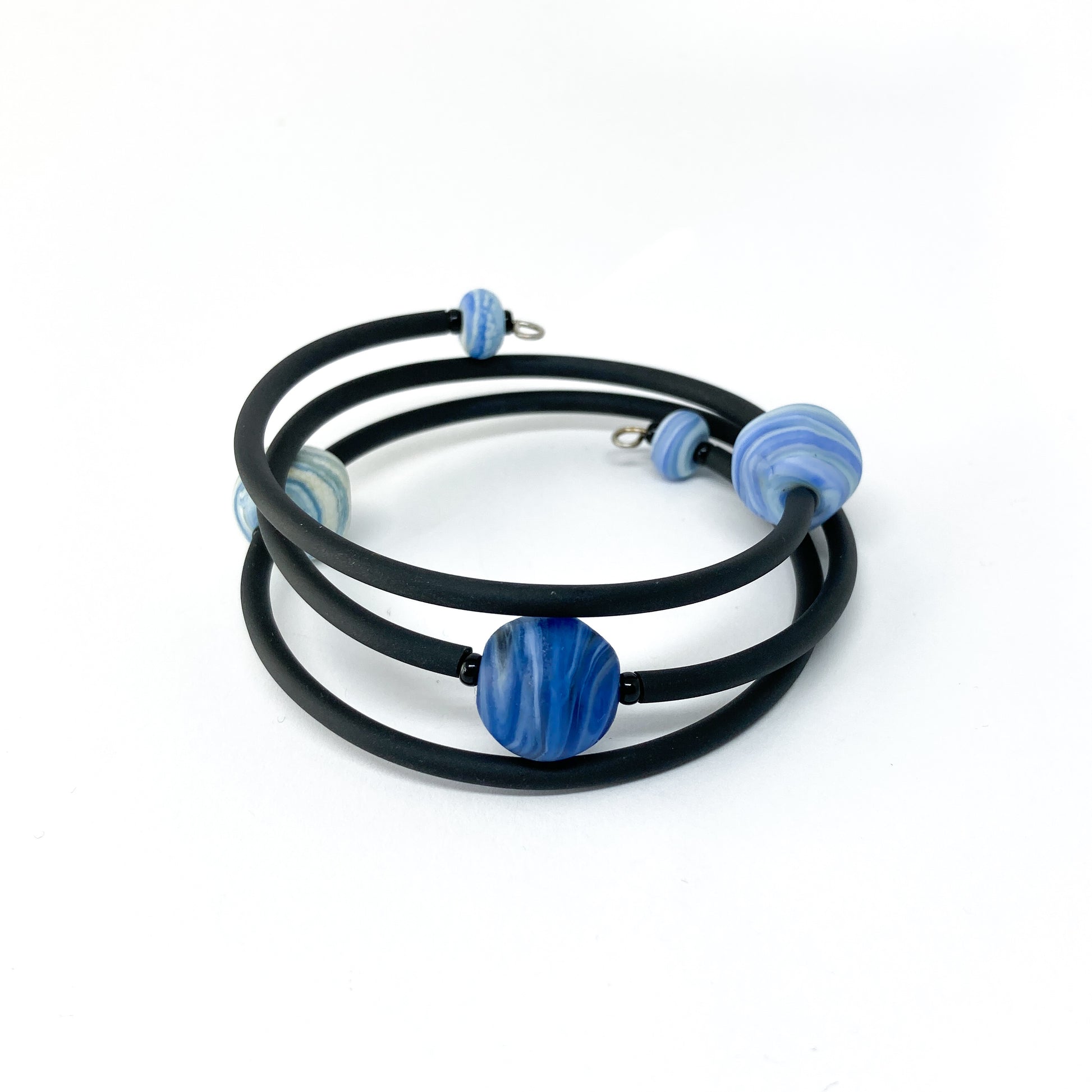 Black rubber bracelet with blue striped beads.