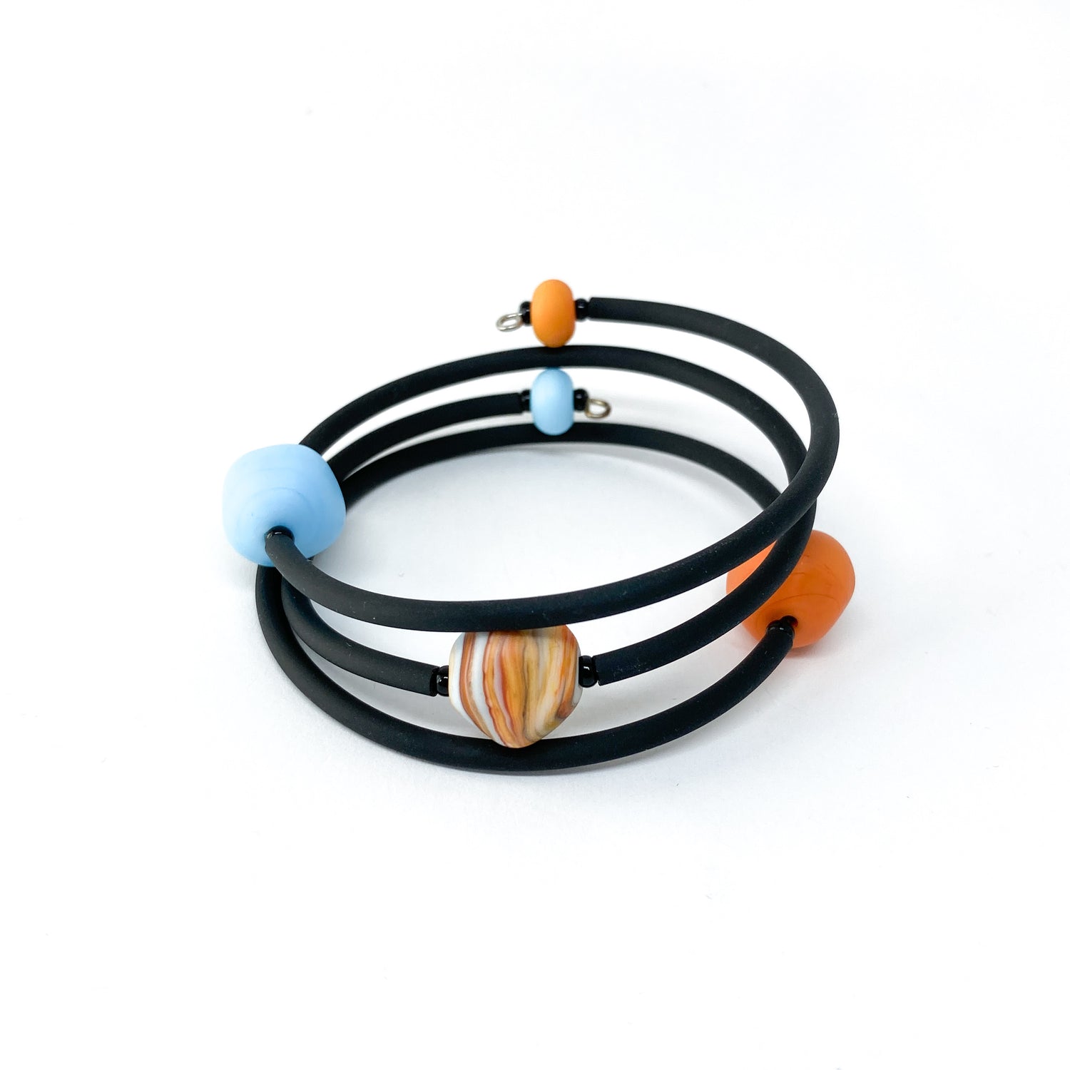 Black rubber bracelet with orange and blue beads, and a larger striped bead.