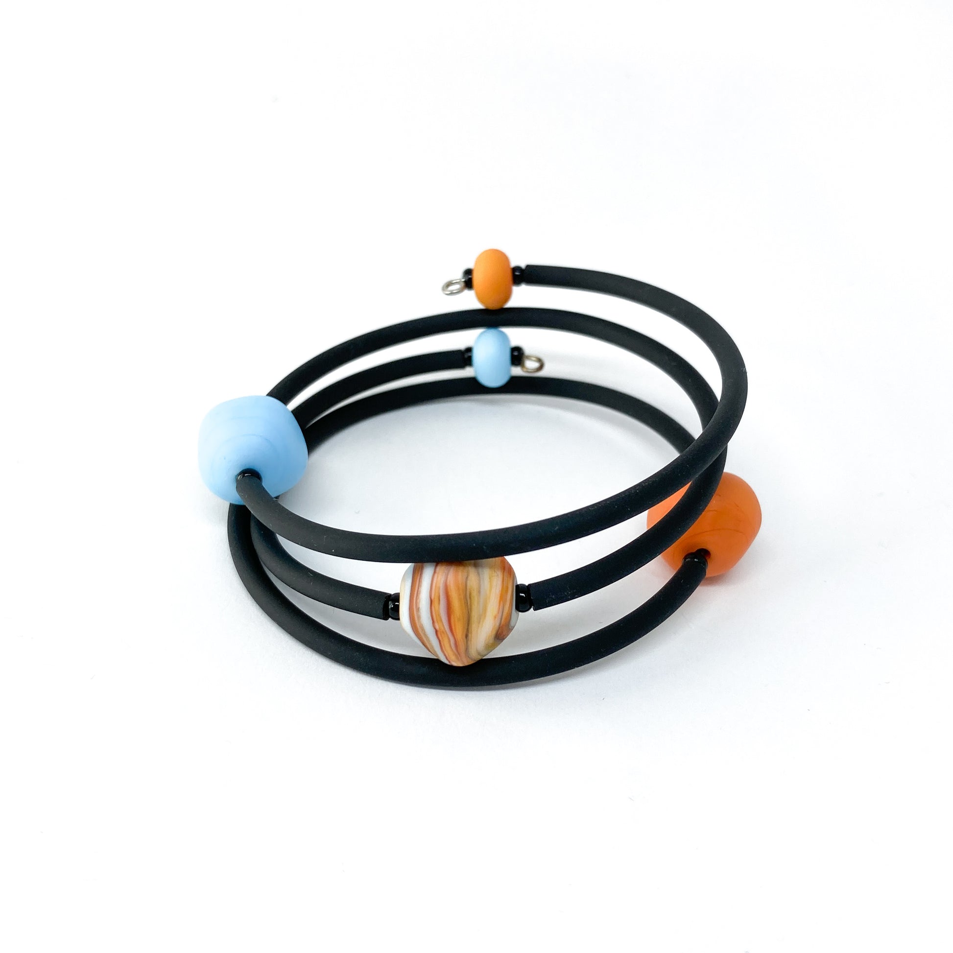 Black rubber bracelet with orange and blue beads, and a larger striped bead.