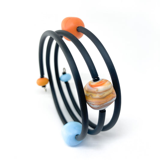 Black rubber bracelet with orange and blue beads, and a larger striped bead.