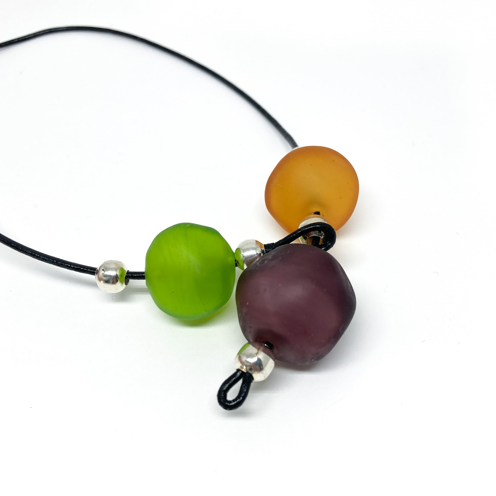 Black cord necklace with green, orange, and purple beads, and silver accents.