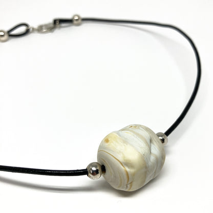 Black cord necklace with a white marbled bead and silver accents.