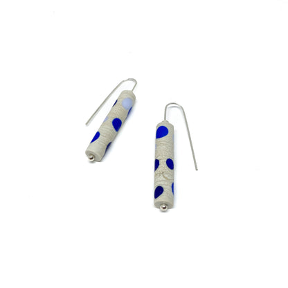 Two cylindrical earrings with blue dots, silver hooks, and small silver beads.
