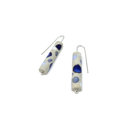 Two cylindrical earrings with purple, blue, and white dots, silver hooks, and small silver beads.