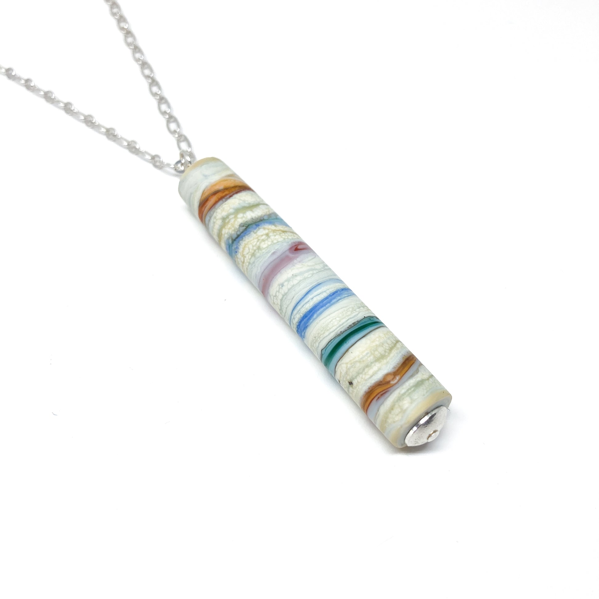 Silver chain necklace with a cylindrical pendant featuring multi-colored stripes and a small silver bead.