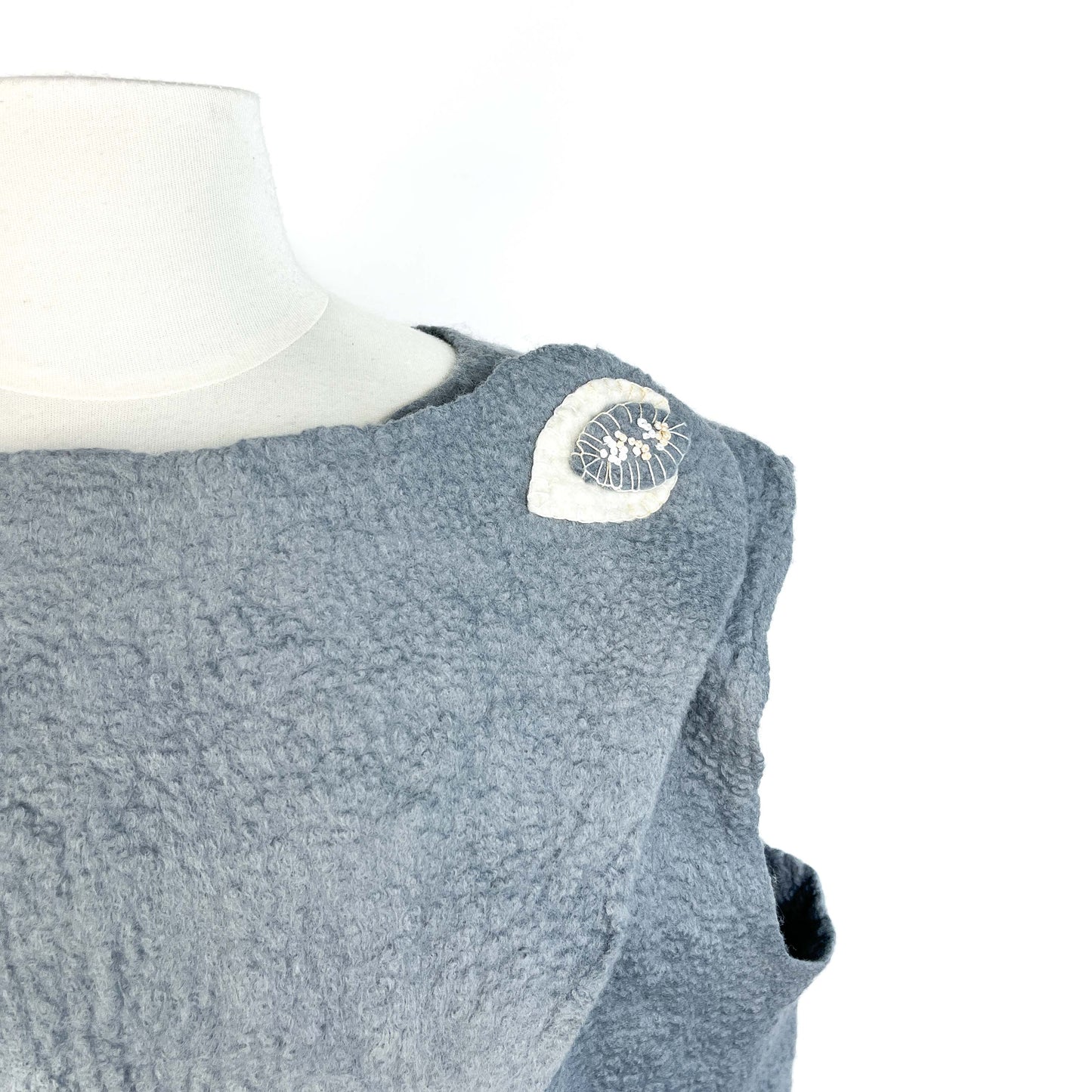 Close-up of a gray Merino Wool Vest showing cotton yarn detail on the shoulder.