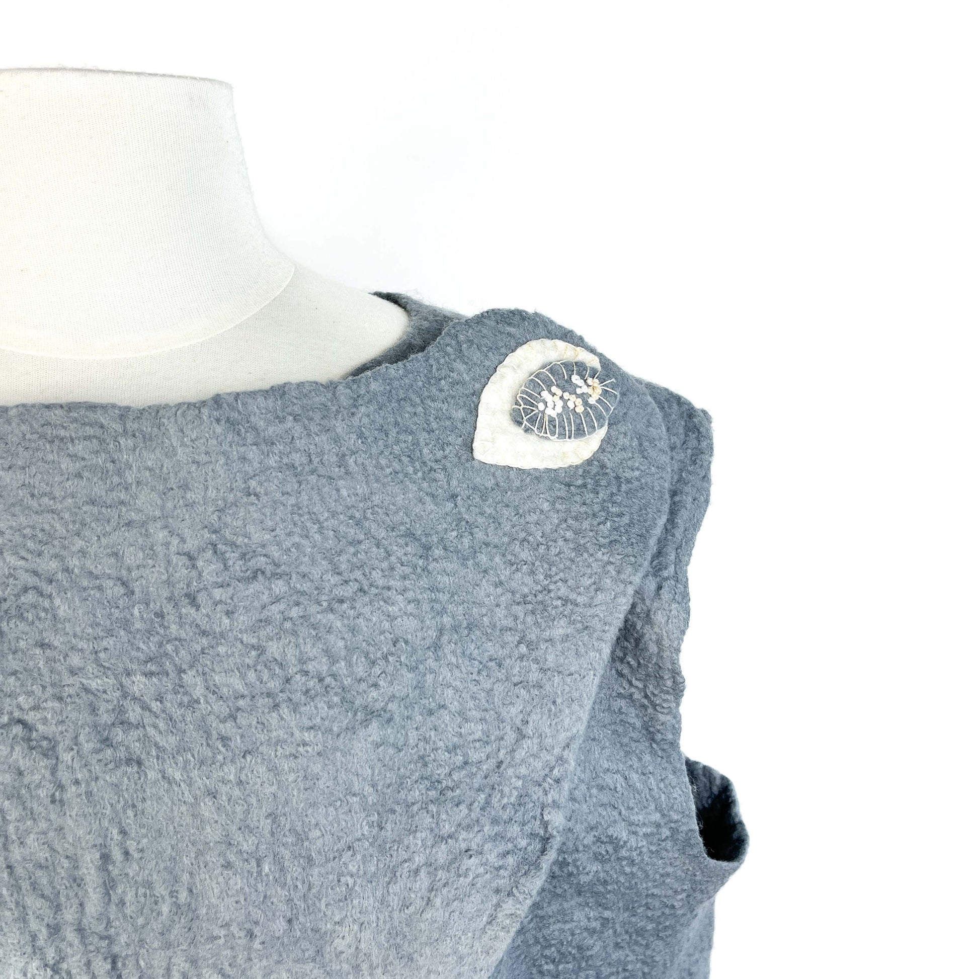 Close-up of a gray Merino Wool Vest showing cotton yarn detail on the shoulder.